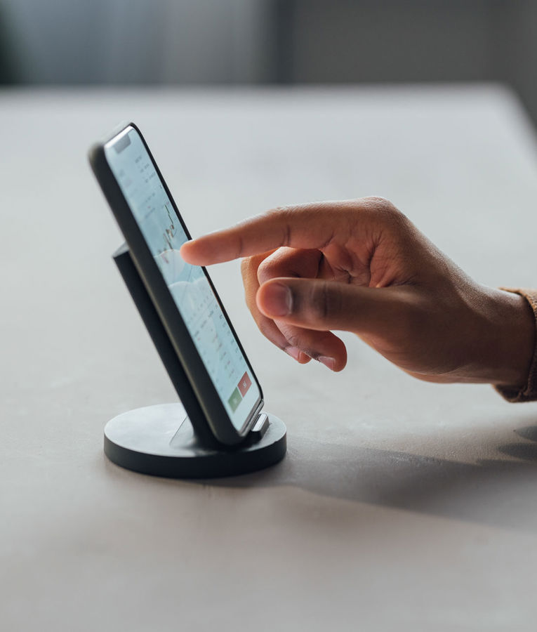 Close-up of a hand using a smartphone for workforce management, scheduling, and time tracking