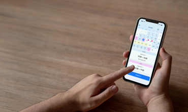 Medarbejder registrerer arbejdstid via mobilapp med kalenderoversigt – nem og effektiv tidsregistrering til løn og overblik.