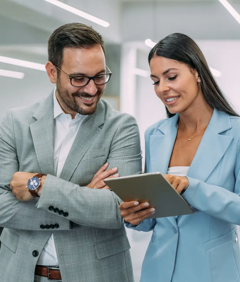Two professionals reviewing workforce data on a tablet, illustrating collaboration in digital scheduling and mobile workforce planning.
